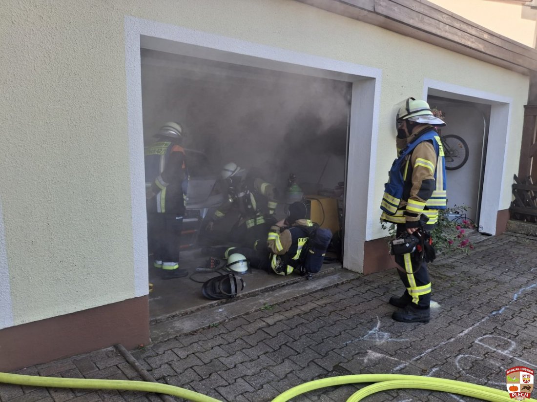 Verqualmte Garage mit Gruppenführe der die Lage von außen beobachtet